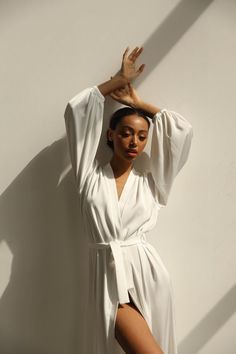 Our long bridal silk robe with wide long sleeves. It could be made of satin or pure mulberry silk. The robe is both casual and elegant, you may wear it on the hen party or spontaneously around your home on a daily basis. It is also an amazing outfit for your vocation, to wear it on the beautiful beach or by the pool as a cover up.-Our model wears size XS, her measurements are 82/61/87 cm and she is 172 cm tall.-Attached with belt.-Arrives beautifully packaged in tissue paper with ribbon -Length White V-neck Robe For Sleep, Satin V-neck Robe For Daywear, Elegant V-neck Kimono For Daywear, Feminine Wedding Robe With Kimono Sleeves, Chic Silk Robe For Sleeping, Elegant Silk Summer Robe, Elegant Long Sleep Kimono, White V-neck Kimono For Daywear, Satin V-neck Daywear Robe