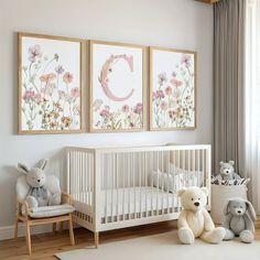 a baby's room with two framed pictures on the wall and stuffed animals in the crib