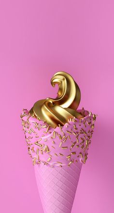 an ice cream cone with gold sprinkles on it and a pink background