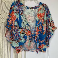 This Is A New With Tag Tropical Wrap Shirt From On The Road, Super Cute As A Top Or As A Swimsuit Cover. Blue Jungle Feather Print Size: Xs Boutique Msrp: $80 Summer V-neck Crop Top For Vacation, Beachwear V-neck Tops With Tropical Print, Casual V-neck Crop Top For Beach, Printed V-neck Crop Top For Summer, Light Blue V-neck Top For Vacation, Floral Print V-neck Tops For Beach Season, Floral Print V-neck Crop Top For Beach, Light Blue Printed V-neck Top, Blue Tops For Beach Season Brunch