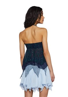 a woman wearing a blue and black top with ruffles on the bottom, back view