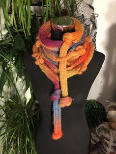 a multicolored knitted scarf hanging on a mannequin's neck