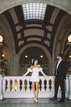 a man standing next to a woman in a white dress