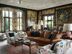 a living room filled with lots of furniture and windows covered in floral fabric coverings