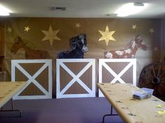 a room with three tables and two horses painted on the wall behind them, along with other decorations