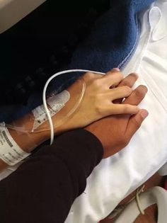 two people holding each other's hands while wearing medical gauze on their arm