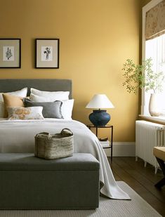 a bedroom with yellow walls and white bedding