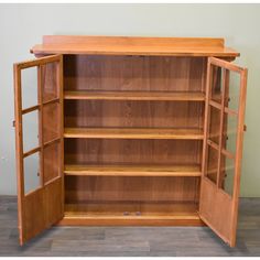 an open wooden bookcase with doors and shelves