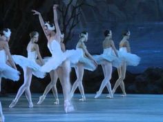 ballet dancers in white tutus are performing on stage