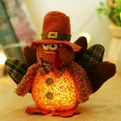 a stuffed turkey wearing a hat and holding a lit candle in it's mouth