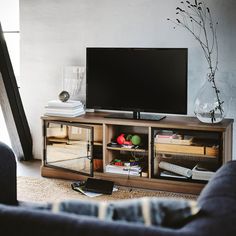 a flat screen tv sitting on top of a wooden entertainment center