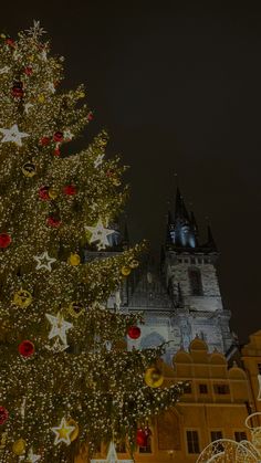 a large christmas tree in front of a castle