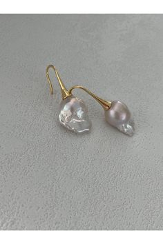 These elegant baroque pearl drop earrings feature unique, organically shaped baroque pearls, each beautifully accentuated by 18k gold-plated silver hooks. The natural luster of the pearls combined with the luxurious gold plating creates a striking piece of jewelry that exudes sophistication and timeless beauty. Perfect for any occasion, these earrings are designed to make a statement. Material: Baroque Pearl, 18k Gold Plated SilverDimensions: Size may vary due to the natural formation of baroque pearlsColor: Vintage Gold Baroque Pearl Earrings, Bar Earrings, Pearl Drop Earrings, Pearl Drop, Gold Plated Silver, Natural Pearls, Baroque Pearls, Gold Accents, Gold Plating