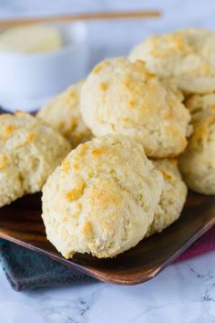 several biscuits on a plate with butter in the background