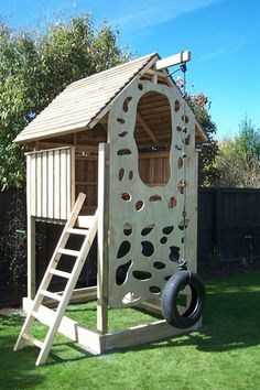 a child's wooden play structure with a swing set and climbing frame in the grass