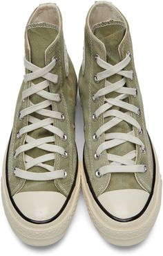 High-top organic canvas sneakers in tones of green. Fading throughout. Round rubber cap toe in off-white. Lace-up closure in white. Eyelet vents and leather logo patch in white and black at inner side. Tonal webbing trim at heel. Rubberized stripe in black at welt. Rubber midsole in off-white featuring stripe in black and logo patch in black at heel. Treaded rubber outsole in brown featuring speckled detailing in off-white. Silver-tone hardware. Supplier color: Light field surplus/Egret Converse White High Tops Chuck Taylors, Leather High Top Shoe, Cool Converse Wornout, Shoe High Tops, Skate Board Converse, Converse 1 Star Green, Converse High Tops Platform Lyst, Converse Cream High Tops, Converse Shoes White High Top