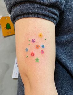 a woman's arm with colorful flowers on it