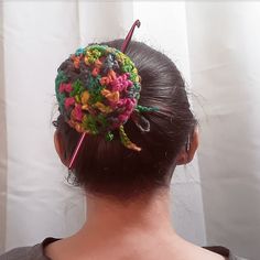 a woman wearing a colorful crochet hair comb