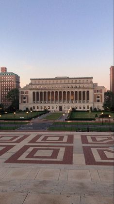 a large building with many windows in front of it and some lights on the ground