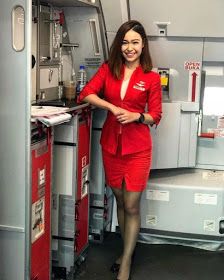 a woman in a red suit standing next to a shelf