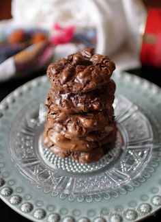 three cookies stacked on top of each other on a glass plate with napkins in the background