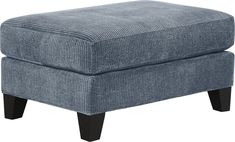 a blue ottoman with black legs on a white background