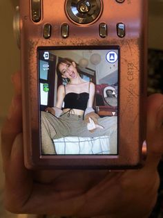 a person holding up a cell phone with a picture of a woman on the screen