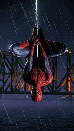 a spider man hanging upside down in the rain