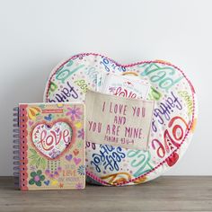 a heart shaped pillow and notebook on a wooden table next to a notepad with the words love you are mine