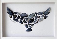 a white frame with some rocks in the shape of a bird on it's back