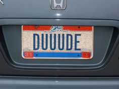 a license plate on the back of a car that says duwude in red, white and blue