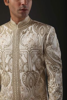 Ivory matka silk sherwani with zari and hand embroidery in floral motifs and silk lined.
Component: 1
Pattern: Embroidered
Type Of Work: Zari
Neckline: Mandarin
Sleeve Type: Full
Fabric: Matka Silk, Lining: Silk 
Color: Ivory
Other Details: 
Zari work
Note: Pant and inner kurta worn by the model is not for sale
Occasion: Groom,Wedding - Aza Fashions Wedding Silk Sherwani For Eid, Silk Sherwani With Zari Work For Wedding, Gold Silk Bollywood Sherwani, Silk Sherwani With Intricate Embroidery For Festivals, Festive Silk Sherwani With Intricate Embroidery, Gold Embroidered Silk Sherwani, Silk Sherwani With Embroidery For Reception, Festival Silk Sherwani With Intricate Embroidery, Gold Silk Sherwani For Eid