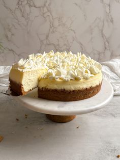 a cheesecake on a cake plate with one slice cut out and ready to be eaten