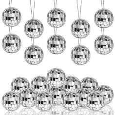 a bunch of shiny disco ball ornaments hanging from chains on a white background with reflections