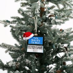 a christmas tree with a sign that says talk nerdy to me on it and a santa hat hanging from the top