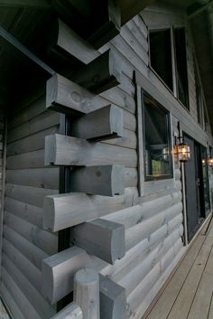 a wooden building with lots of windows on the front and side of it that is made out of wood planks