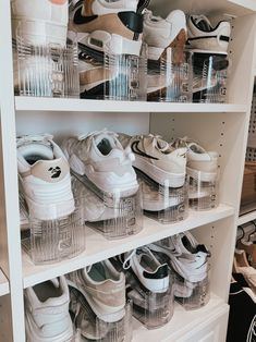 many pairs of shoes are on shelves in a closet with clear bins and plastic containers