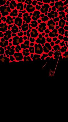 a red and black animal print pattern with scissors in the middle on a black background