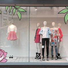 a window display with mannequins and dresses in it's glass case