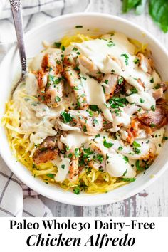 a white bowl filled with pasta and meat covered in sauce