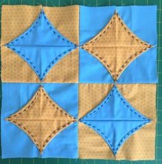 a blue and brown quilted square with stitching on it