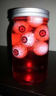 a jar filled with red balls sitting on top of a table