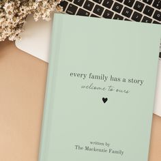 a book sitting on top of a desk next to a laptop computer and keyboard with the title every family has a story welcome to you