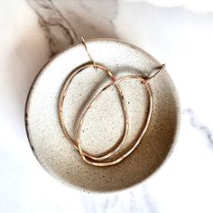 Bring out your bold side with these medium organic oval hoop earrings! Perfect for date night, they'll add a sultry edge to your look. Lightweight and shimmering, they won't bog you down when you're out with your friends. Strike a balance between statement and style with these gold hoops. Measures 2" long, 1.5" wide 100% nickel-free made from 14kt gold-filled Jewelry care card and storage bag for earrings 1-year free professional cleaning from the date of purchase by The Pink Locket jewelry stud Pink Locket, Jewelry Care Card, Locket Jewelry, Oval Hoop Earrings, Hammered Hoop Earrings, Jewelry Lockets, Jewelry Studio, Earrings Unique, Care Card