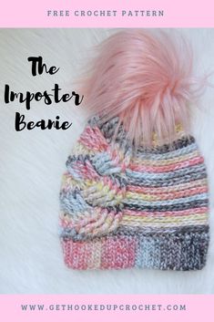 a knitted hat with pink pom - pom on top and the words, the imposter beanie