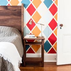 a bed sitting next to a wooden headboard on top of a hard wood floor