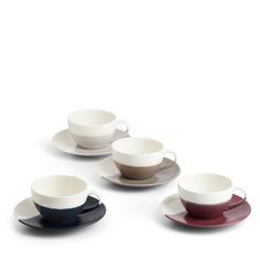 four cups and saucers in different colors