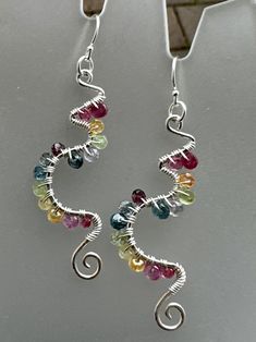 These gorgeous sterling earrings laden in colorful gemstones are reminiscent of vines, new birth, awakening, and longing for spring! The sterling frames are hand shaped in a unique abstract swirling pattern, and hammered for a shimmery texture. Gemstones wrapped in sterling wire add more sparkle to these frames. Finished with sterling ear wires and components.  Gemstones include: Spinel Sapphire Kyanite Tanzanite  Peridot Topaz Citrine Excellent gift idea for that free spirited friend or family Whimsical Multicolor Sterling Silver Jewelry, Whimsical Multicolor Wire Wrapped Jewelry, Artsy Multicolor Sterling Silver Jewelry, Multicolor Teardrop Whimsical Jewelry, Multicolor Wire Wrapped Sterling Silver Earrings, Artsy Sterling Silver Multicolor Jewelry, Wire Earrings Handmade, New Birth, Wire Jewelry Patterns