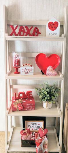 valentine's day decorations are displayed on shelves in a room with white walls and carpet