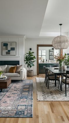 a living room filled with furniture and a rug on top of a hard wood floor